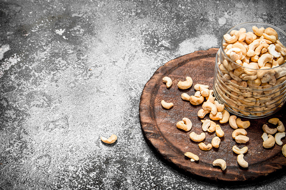 Cashewnüsse in einer Schüssel auf einem Holzbrett